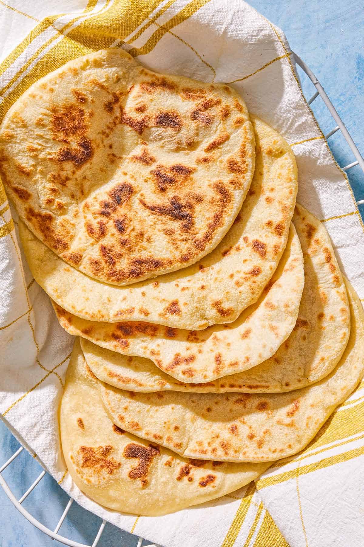 Six pieces of the yogurt flatbread in a towel-lined basket.