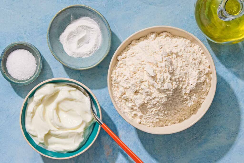 Ingredients for the flatbread recipe including Greek yogurt, flour, baking powder, salt, and olive oil.