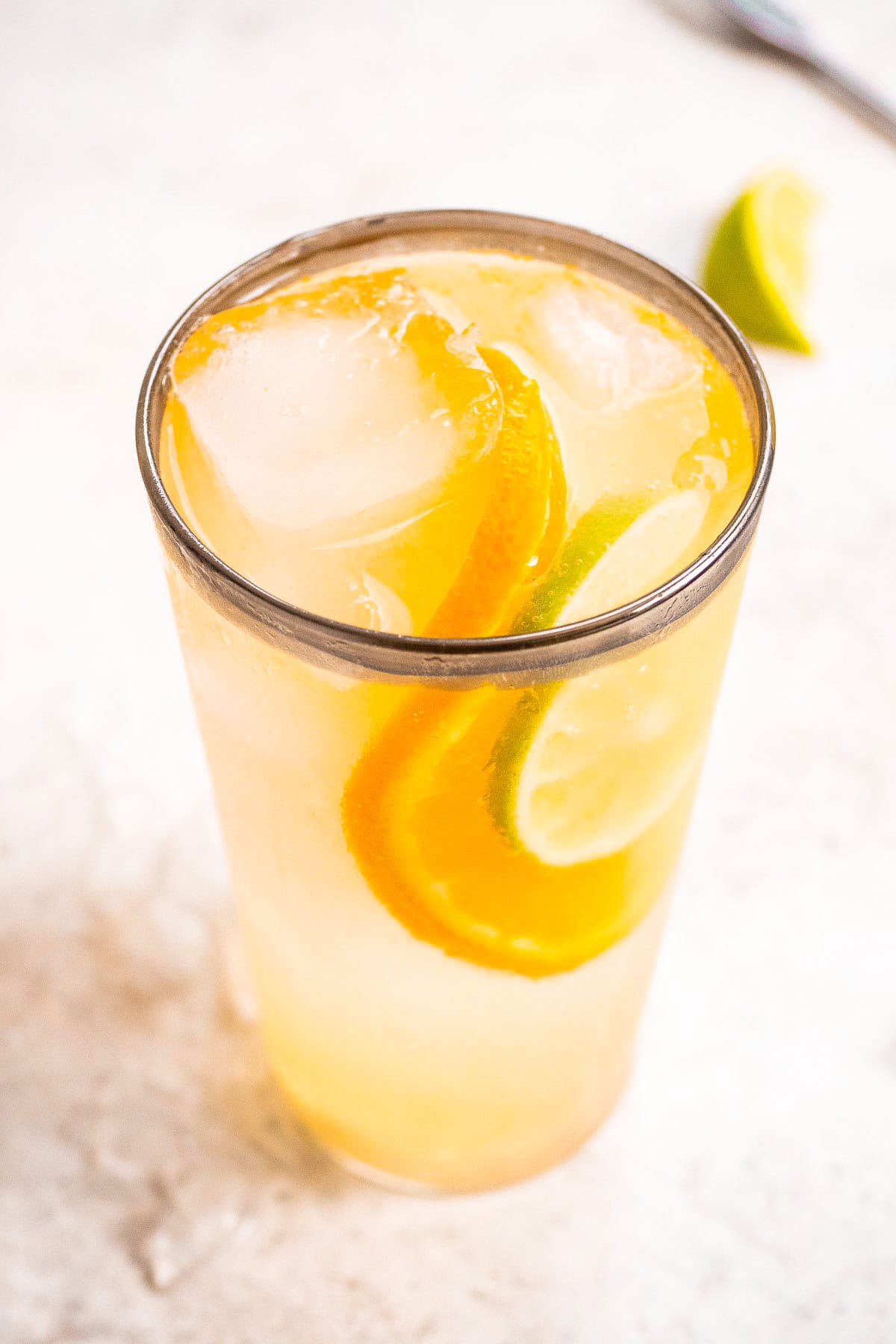 An overhead photo of the gin cocktail with a garnish of a lime and orange slice.