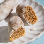 A whole alfajores along with two halves on a plate.
