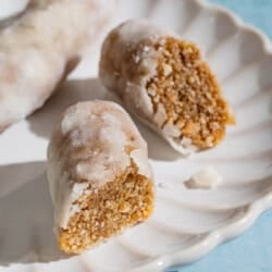 A whole alfajores along with two halves on a plate.