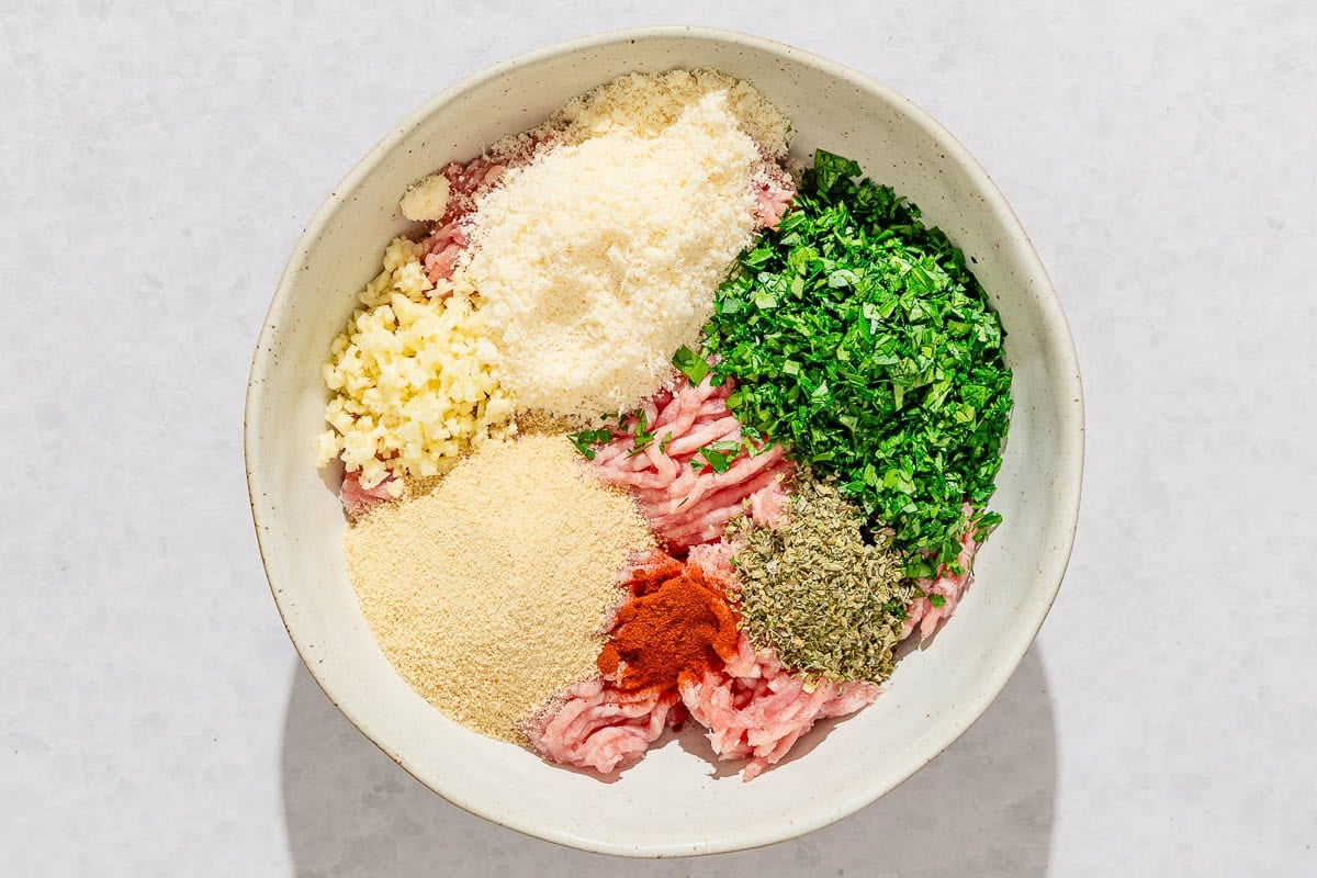 The ingredients for the baked chicken meatballs in a bowl just before being mixed together.