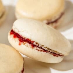 A close up of a macaron leaning against another on a plate.