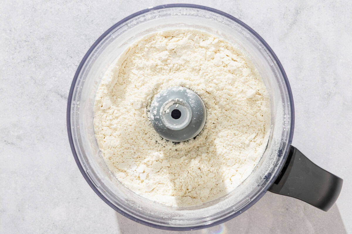 The dry ingredients mixed together in the bowl of a food processor.