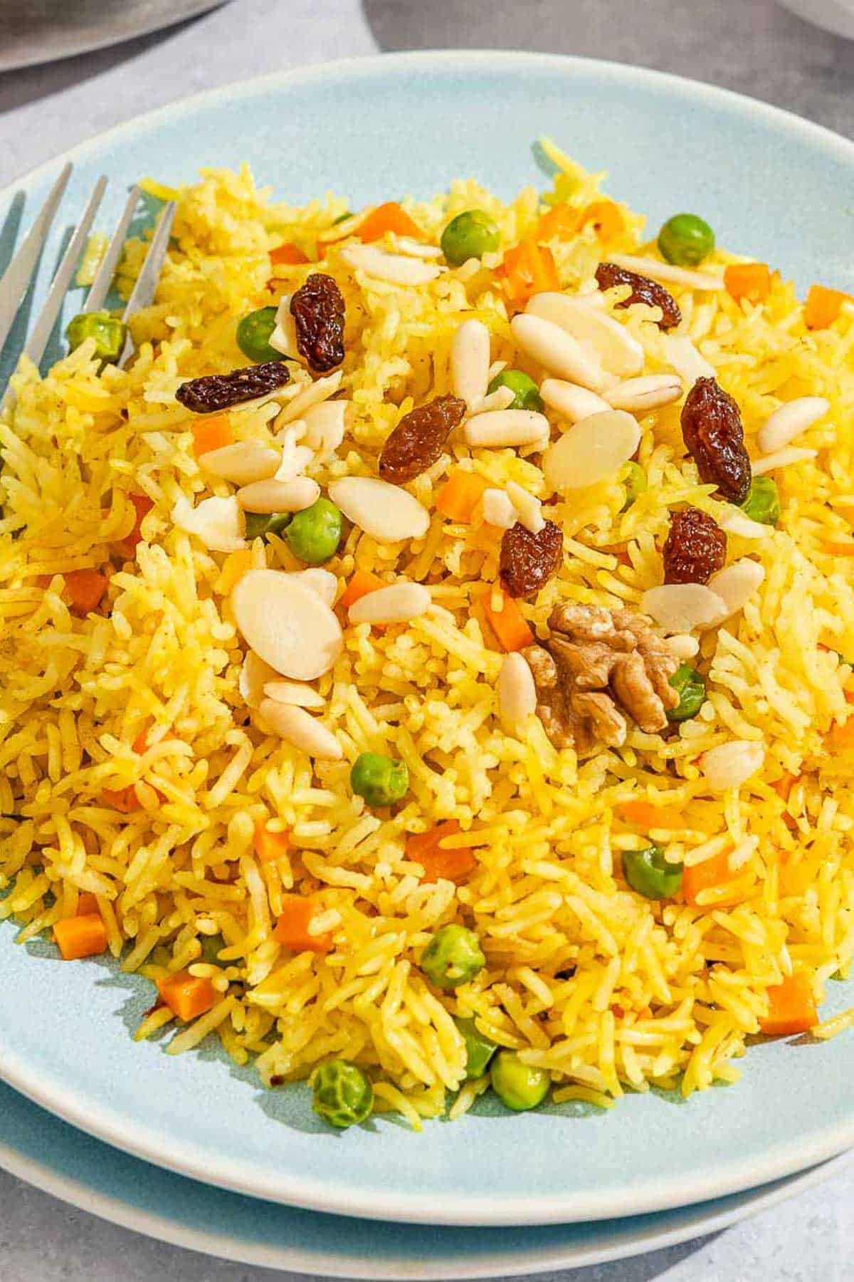 A serving of rice pilaf on a plate with a fork.