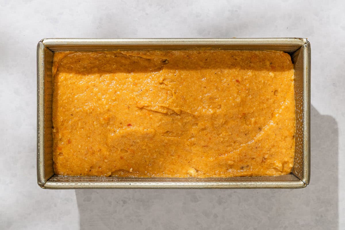 The batter for the persimmon bread recipe in a loaf pan.