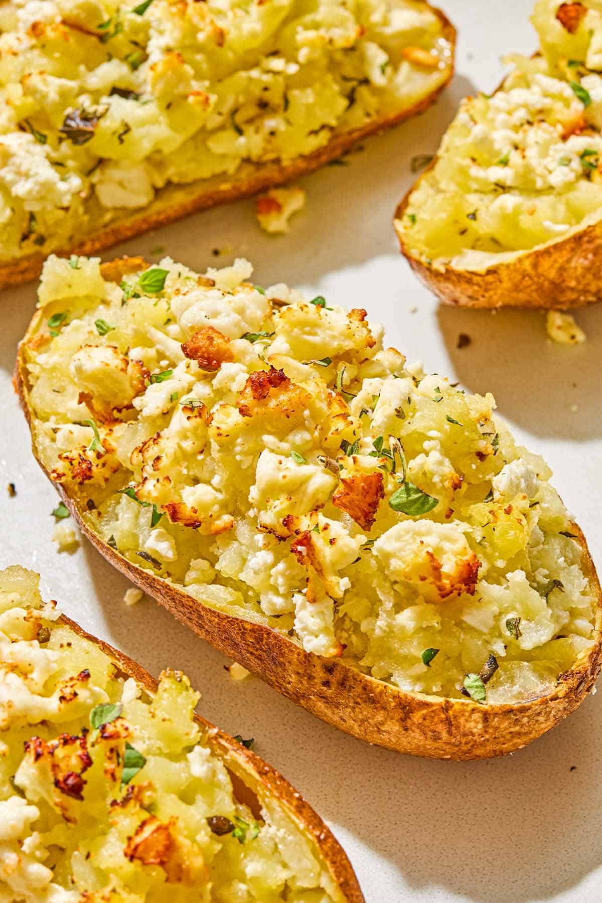 A close up of a twice baked potato surrounded by other twice baked potatoes.