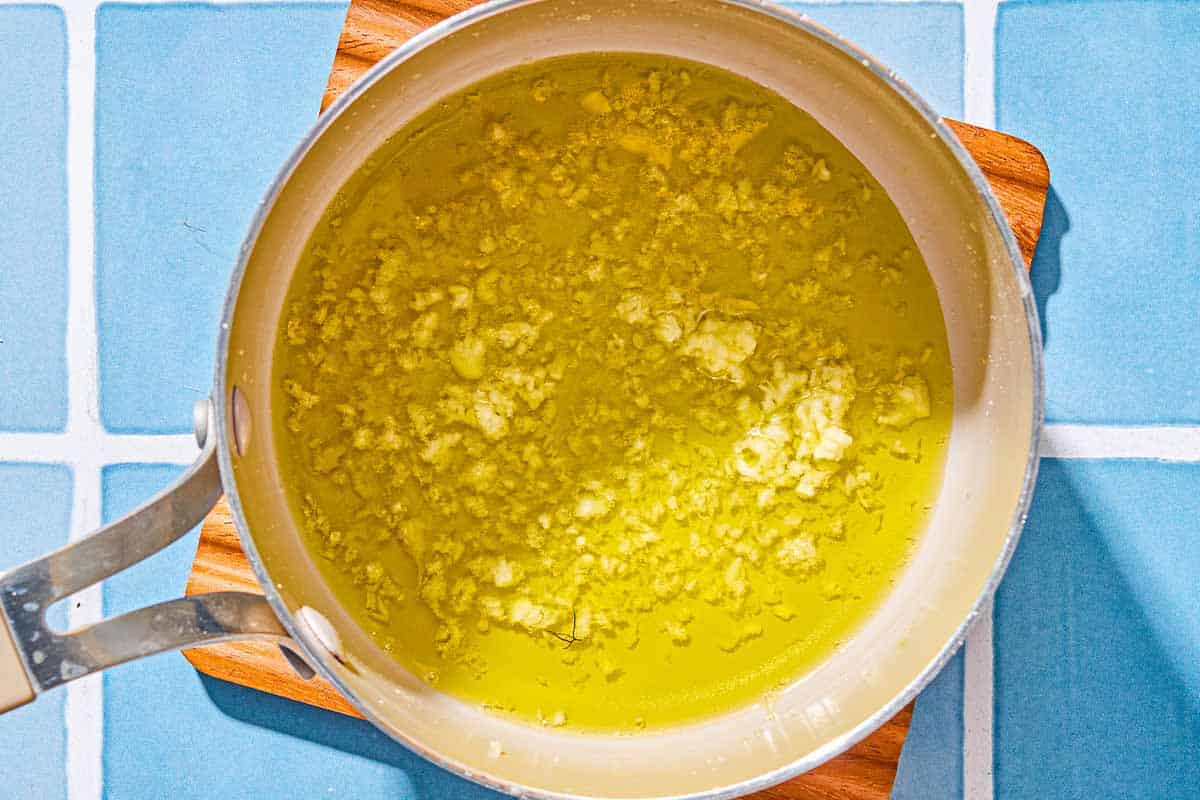 The garlic oil for the twice baked potatoes in a saucepan on a trivet.