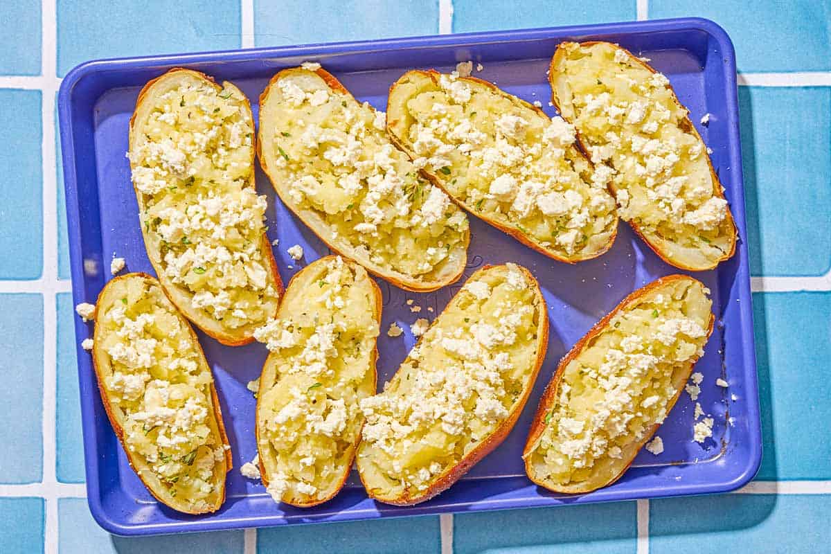 Several twice baked potatoes on a sheet pan.