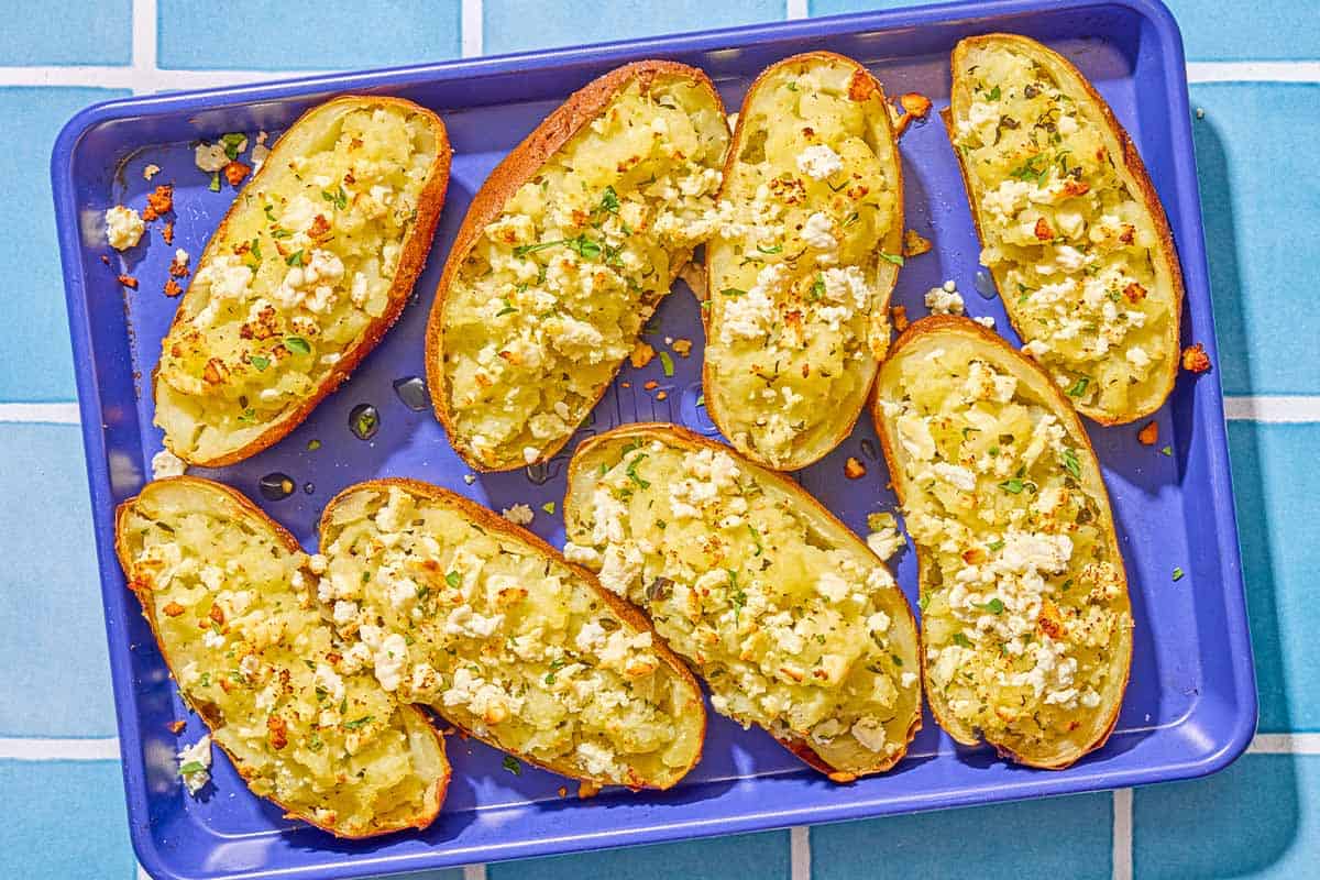 Several twice baked potatoes on a sheet pan.