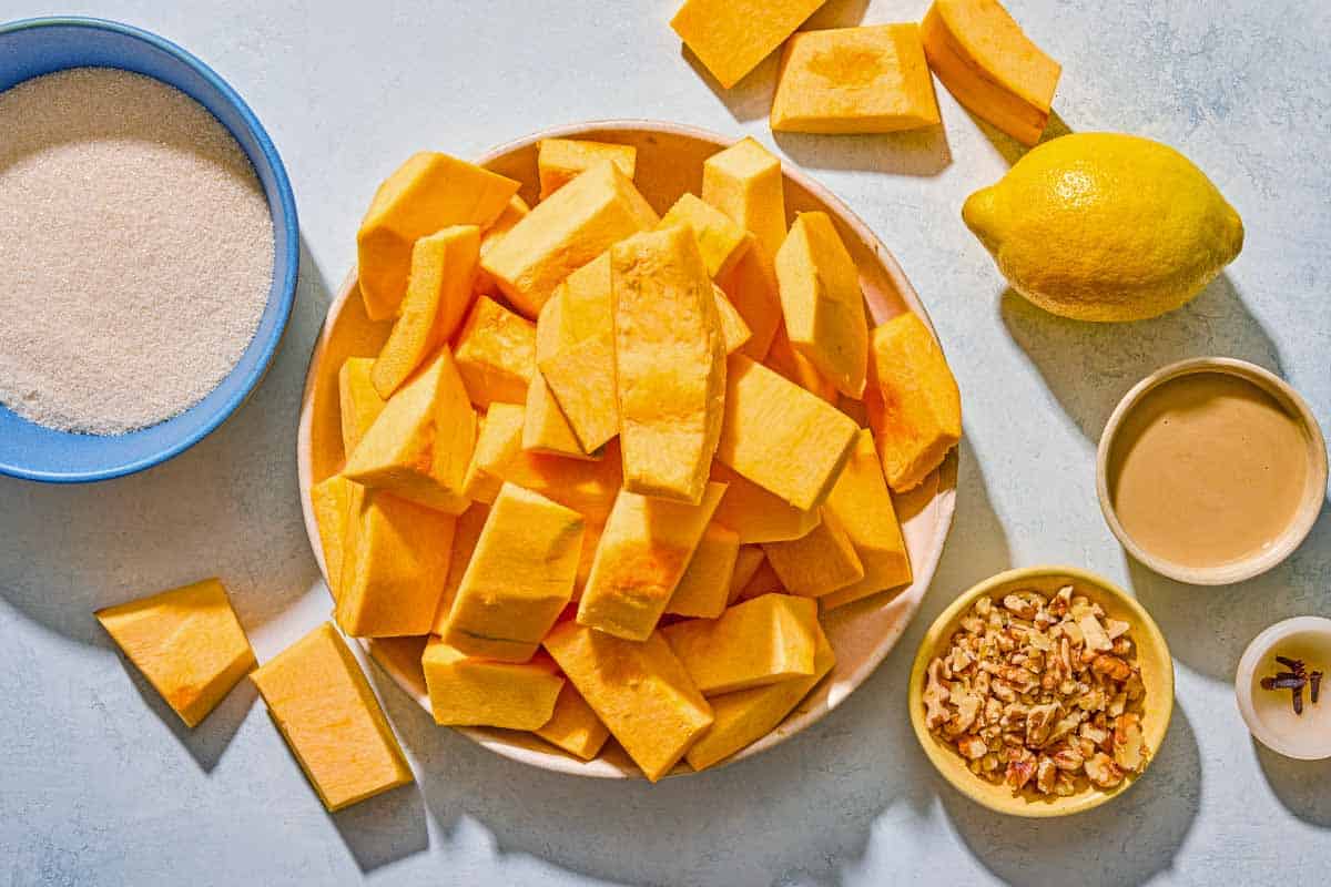 Ingredients for Kabak Tatlisi including pumpkin, sugar, cloves, lemon, walnuts and tahini.