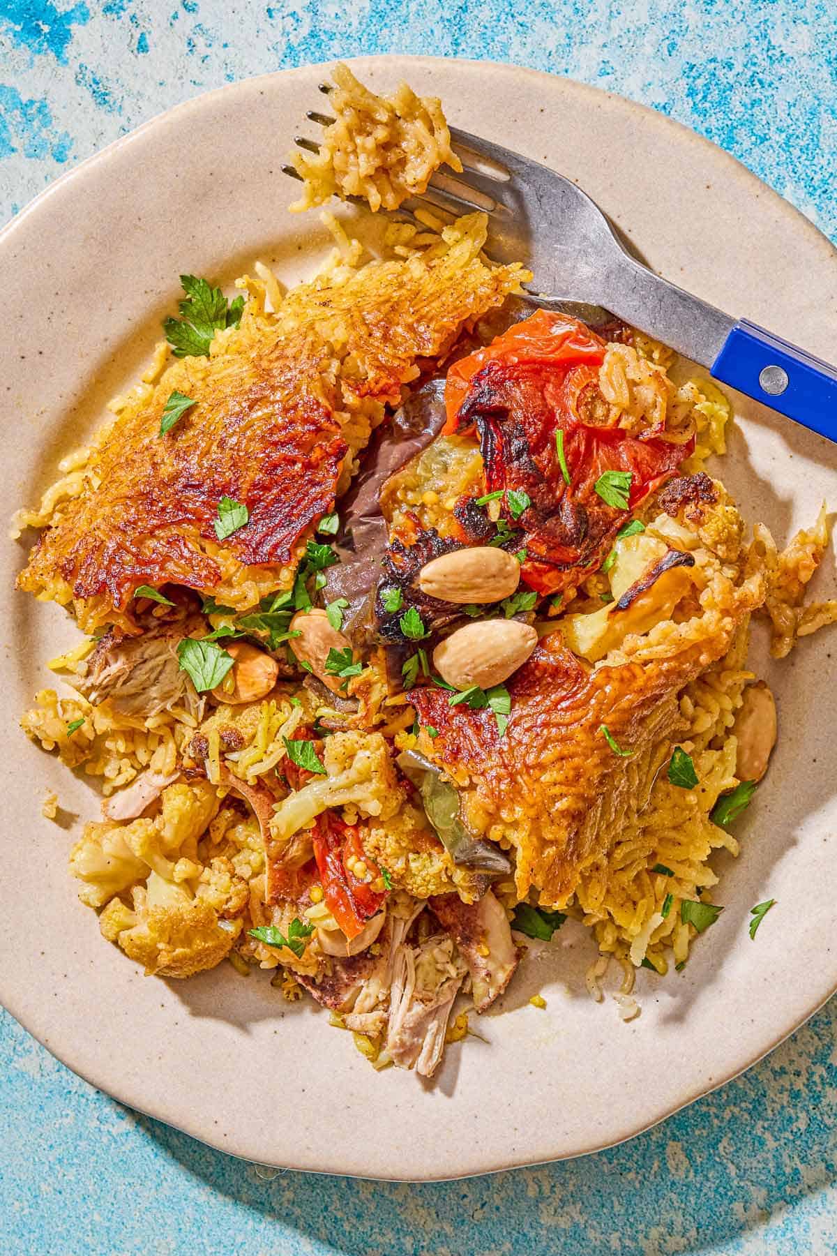 A serving of maqluba on a plate with a fork.