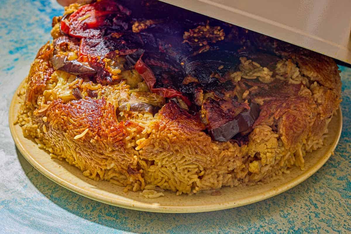 The maqluba being moved from the pot to the platter.