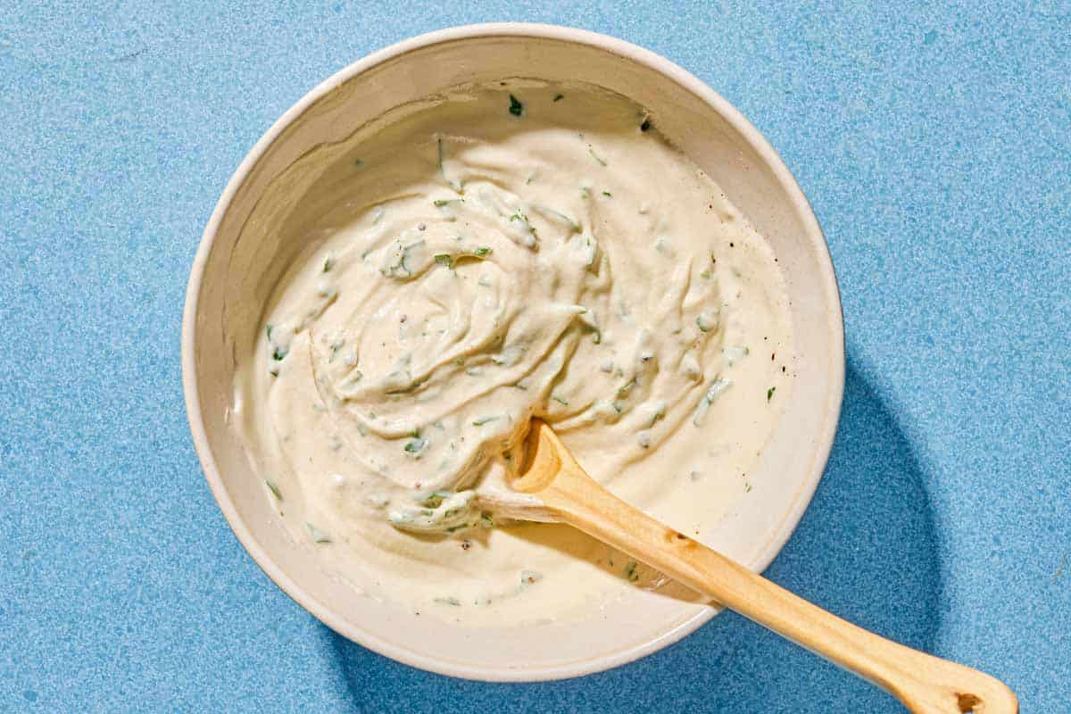 Tahini sauce in a bowl with a spoon.