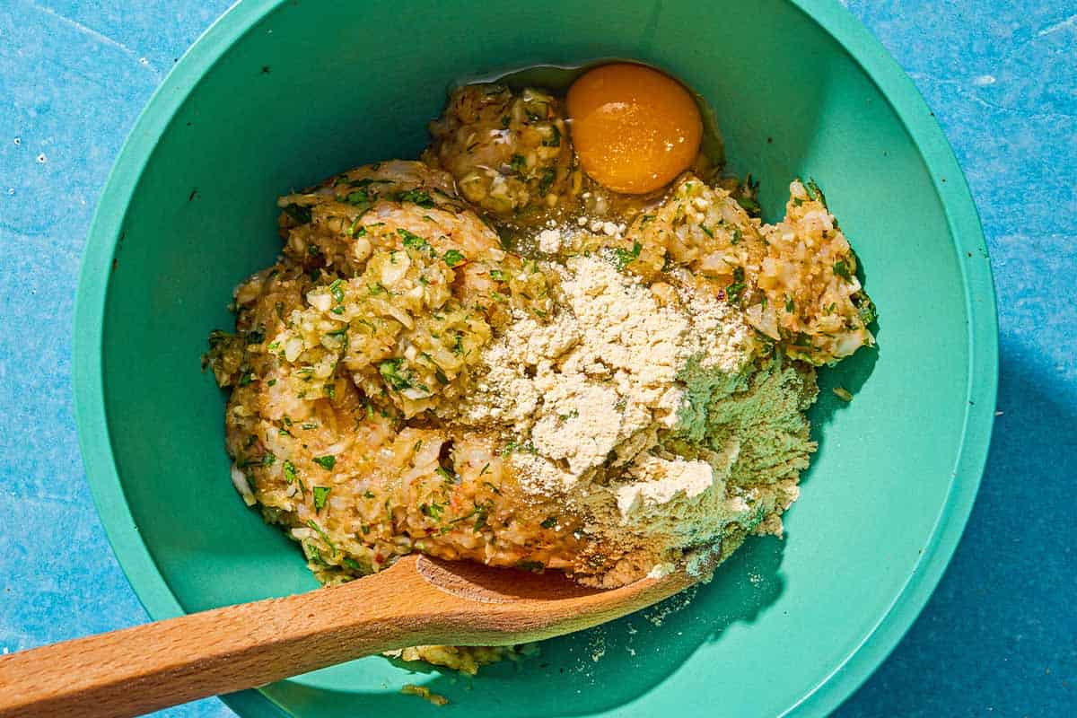 The ingredients for the shrimp kofta being mixed together with a wooden spoon.