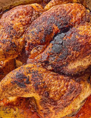 The whole cooked spatchcock chicken in a skillet.