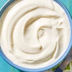 The toum recipe in a bowl. Next to this is a spoon on a napkin.