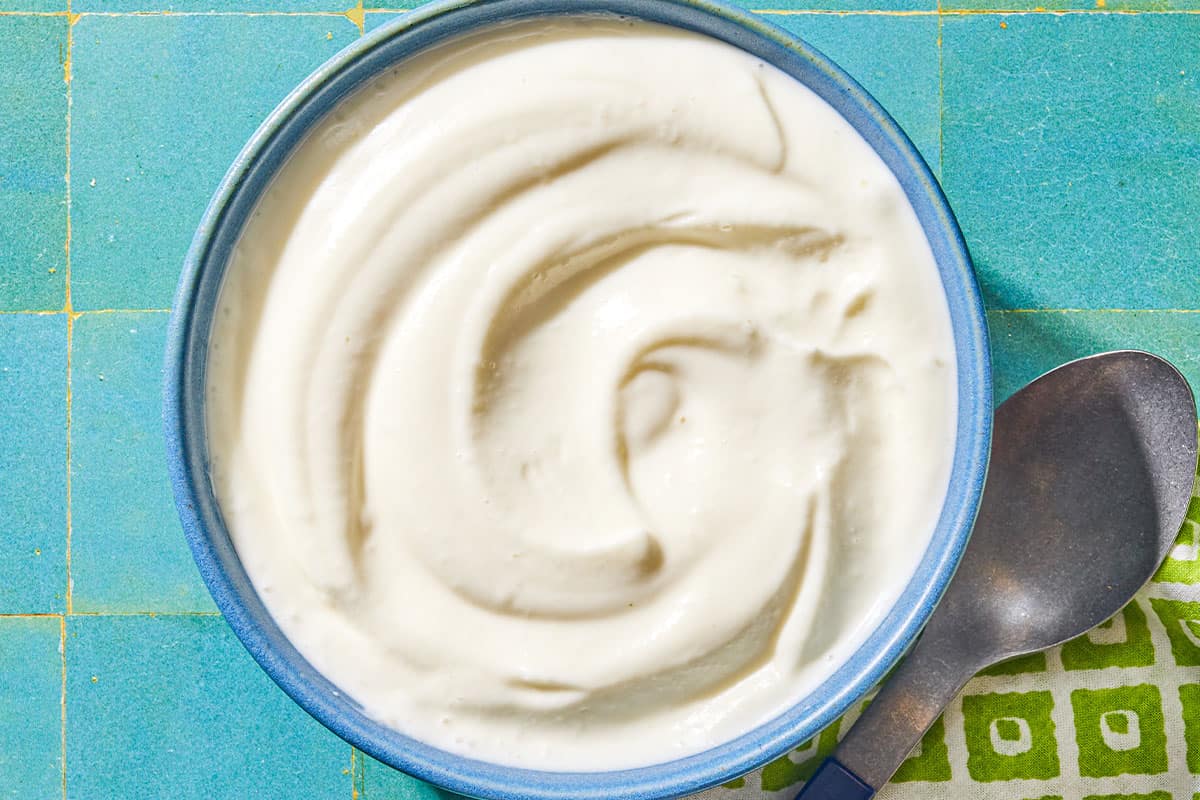 The toum recipe in a bowl. Next to this is a spoon on a napkin.