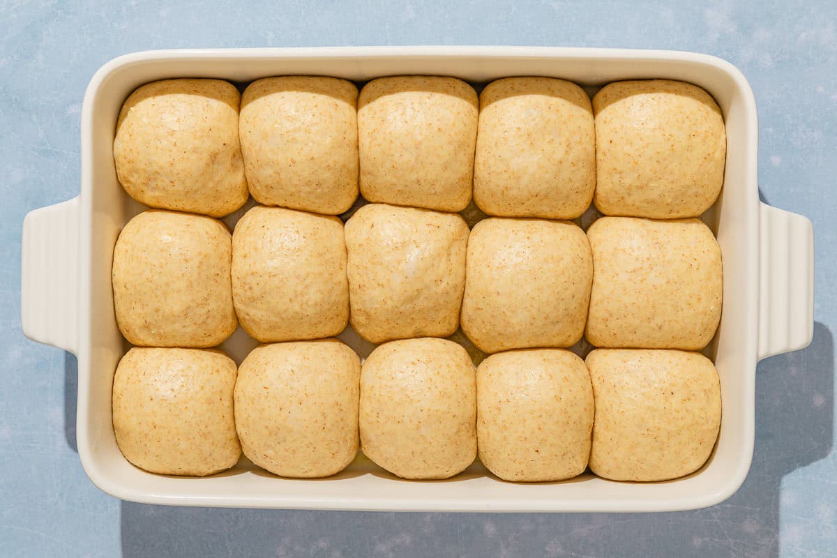 Unbaked dinner rolls in a baking dish.