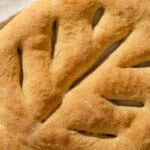 A close up of baked fougasse on a kitchen towel.