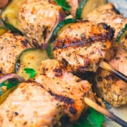 A close up of salmon kabobs on a platter.