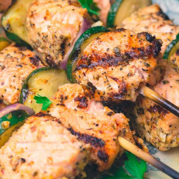 A close up of salmon kabobs on a platter.