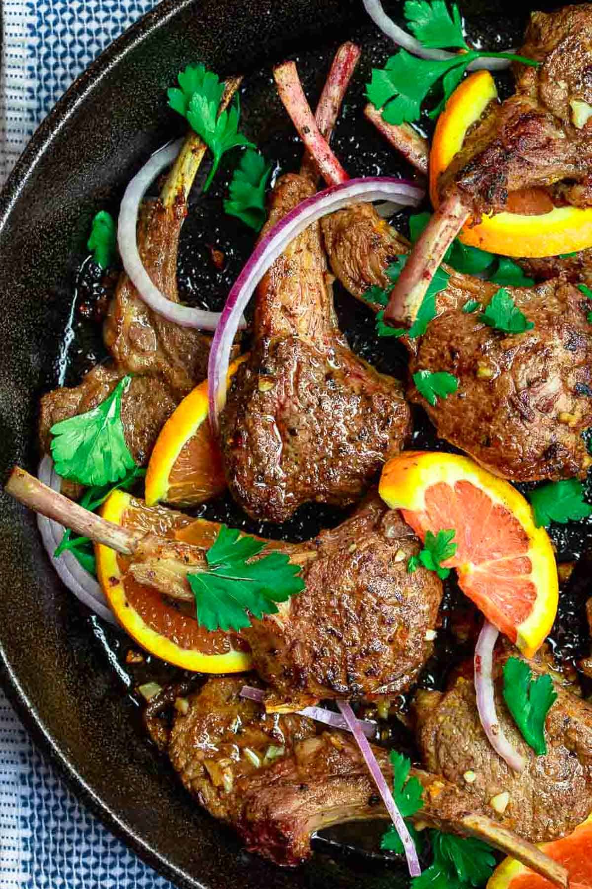 An overhead photo of the lamb chops recipe in a cast iron skillet.