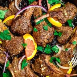 An overhead photo of the lamb chops recipe in a cast iron skillet.