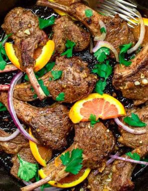 An overhead photo of the lamb chops recipe in a cast iron skillet.