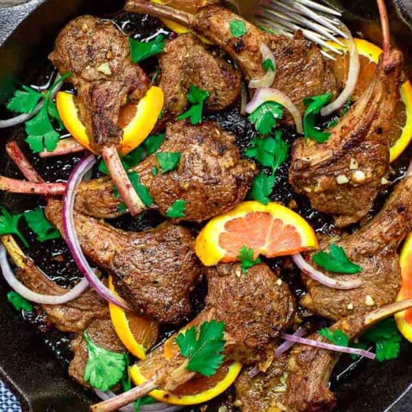 An overhead photo of the lamb chops recipe in a cast iron skillet.