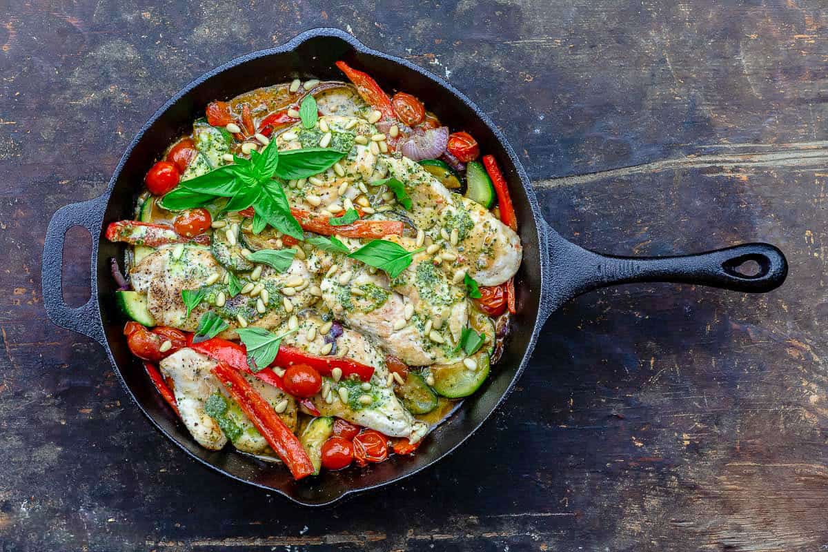 An overhead photo of the pesto chicken recipe in a cast iron skillet.