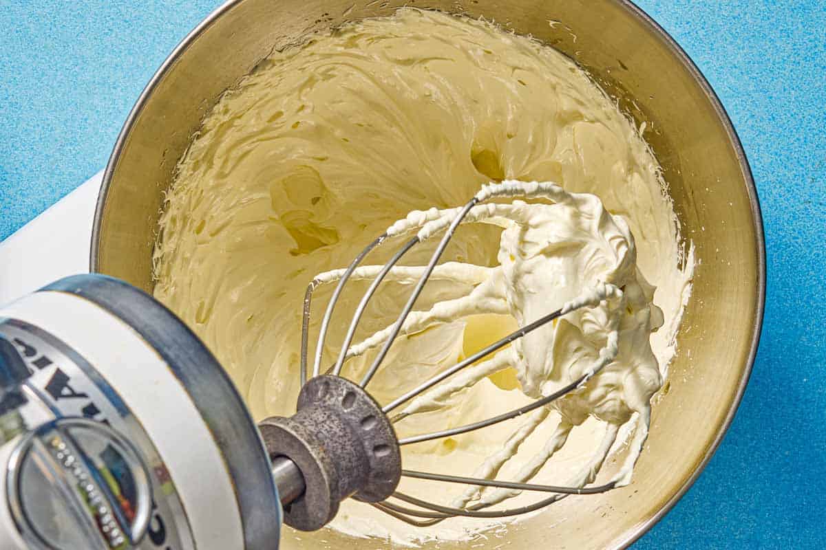 The olive oil and the butter mixed together in the bowl of a stand mixer after being whisked together.