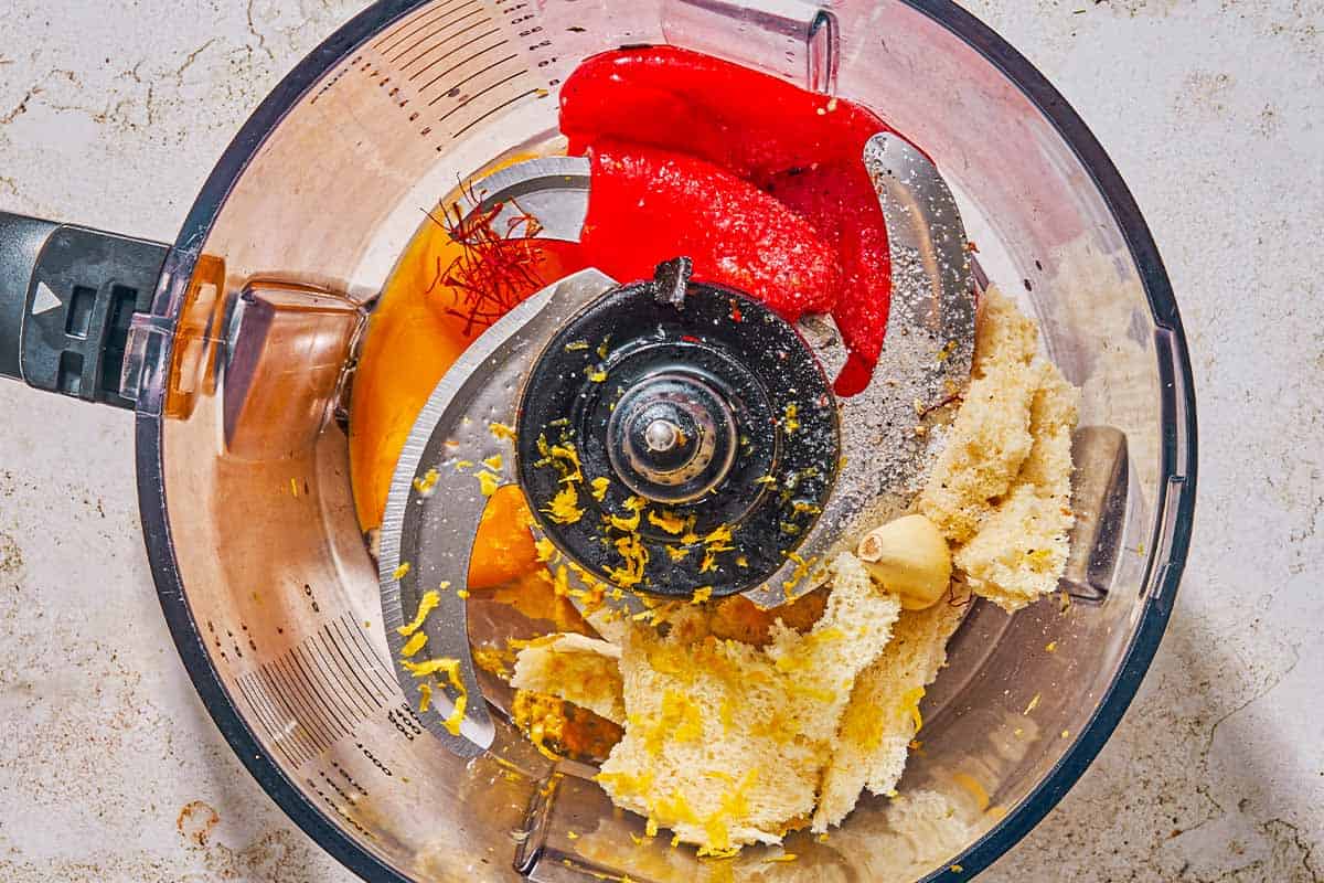 The ingredients for the rouille in the bowl of a food processor just before being pureed.