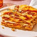 A close up of a slice of butternut squash lasagna on a plate.