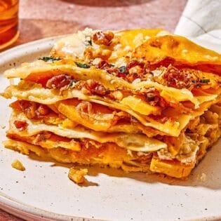 A close up of a slice of butternut squash lasagna on a plate.