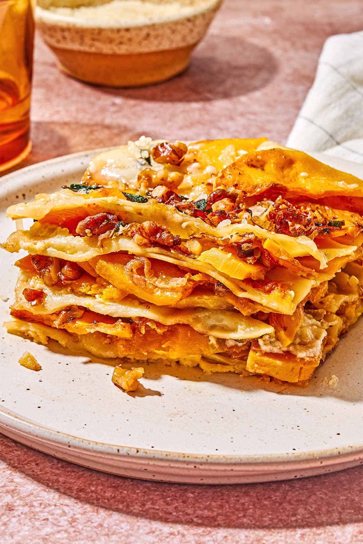 A close up of a slice of butternut squash lasagna on a plate.