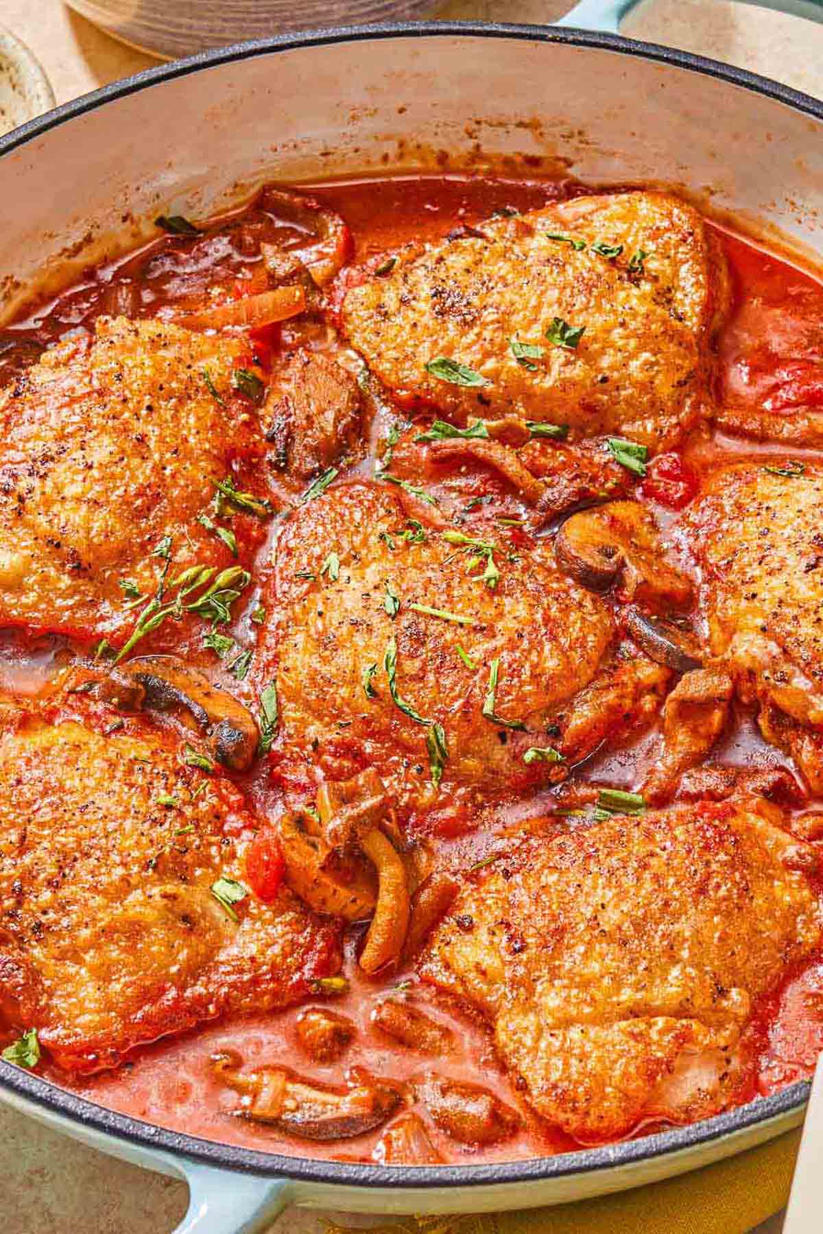 A close up of chicken chasseur in a skillet.