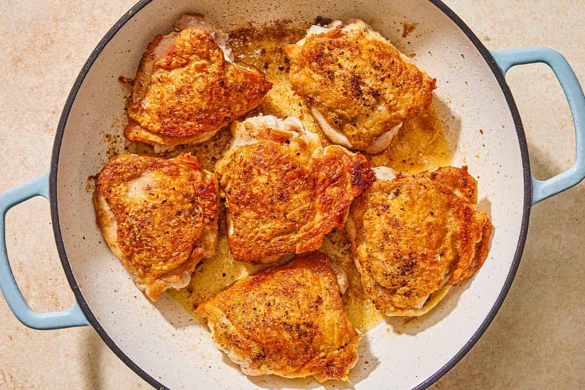 Chicken thighs for the chicken chasseur being browned in a skillet.