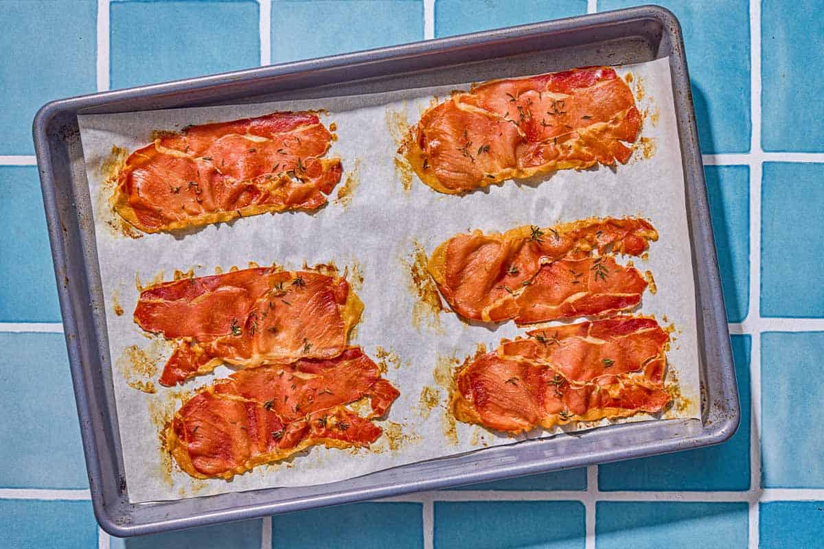 Crispy roasted prosciutto on a parchment lined sheet pan.