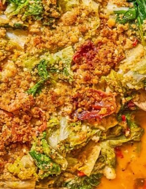 An overhead photo of utica greens in a skillet with a wooden spoon.