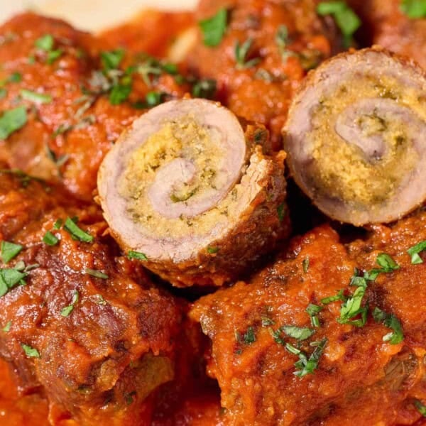 Beef braciole with marinara sauce on a plate.