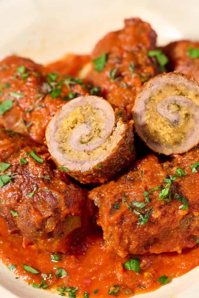Beef braciole with marinara sauce on a plate.