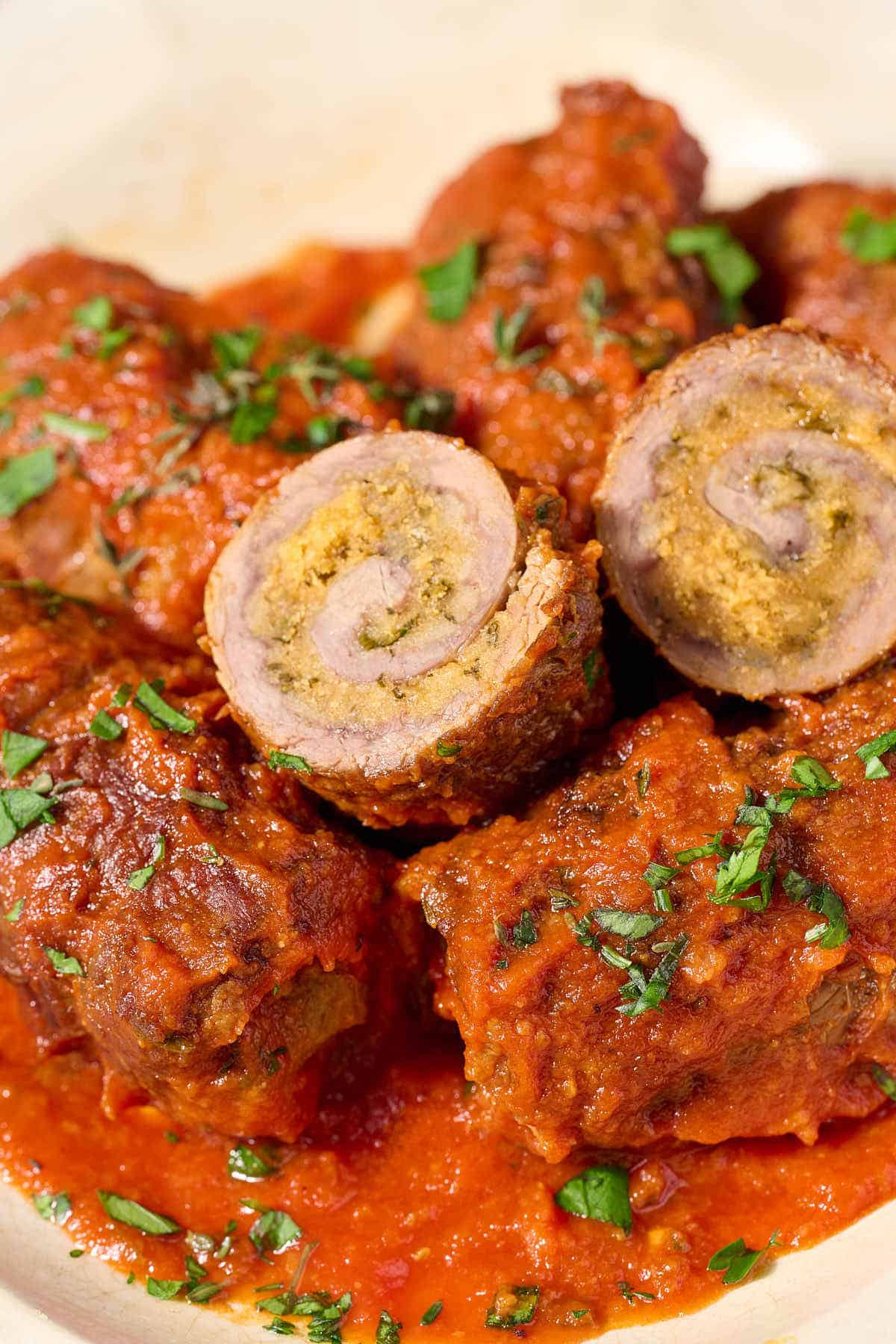 Beef braciole with marinara sauce on a plate.
