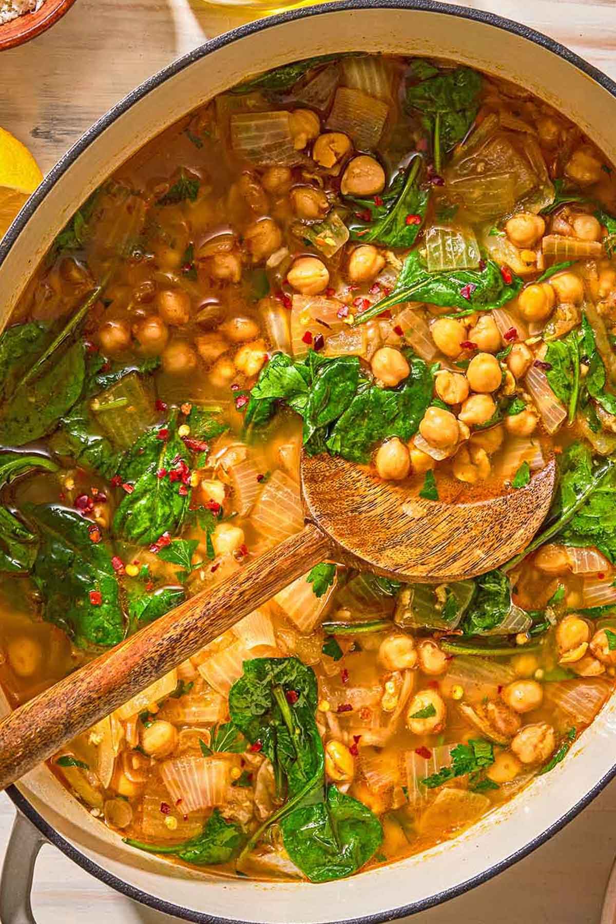 Spinach soup in a pot with a wooden spoon.