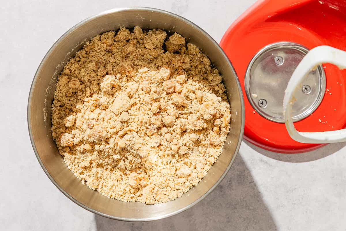 The apricots, walnuts, vanilla extract, brown sugar, white sugar, and butter for the apricot cookie recipe in the bowl of a stand mixer.