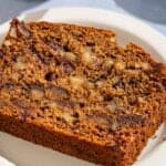 A slice of date nut bread on a plate.