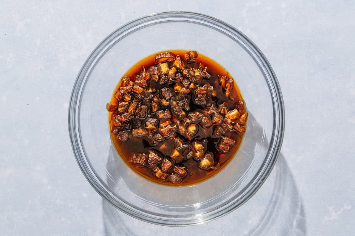 The chopped dates for the date nut bread recipe soaking in a bowl.