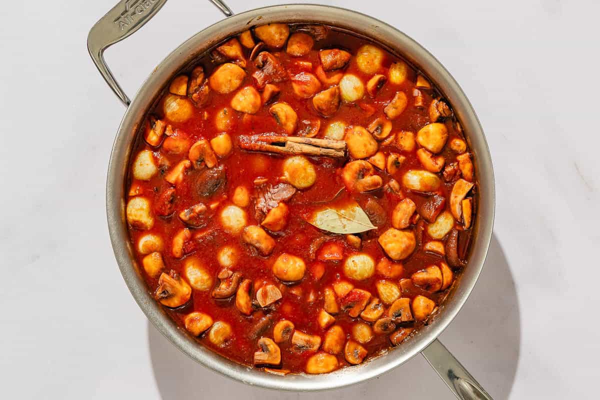 The mushroom stew cooking in a tall sided skillet.
