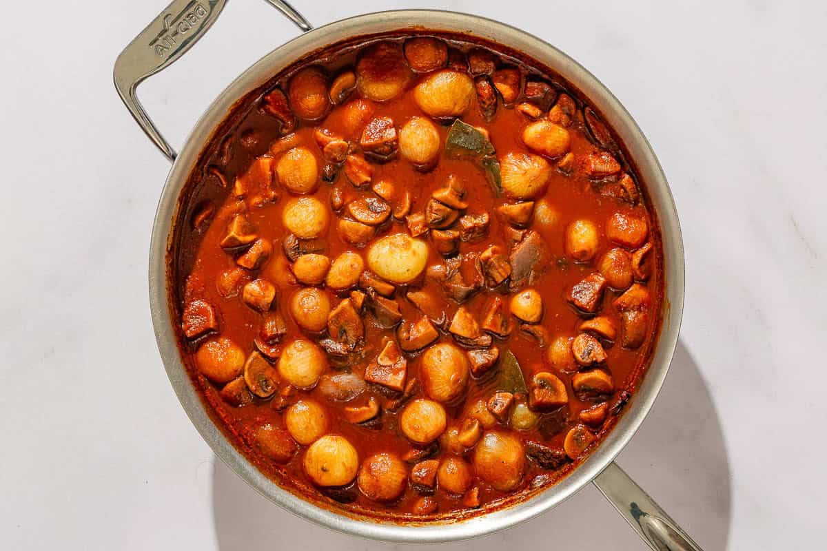 The mushroom stew cooking in a tall sided skillet.