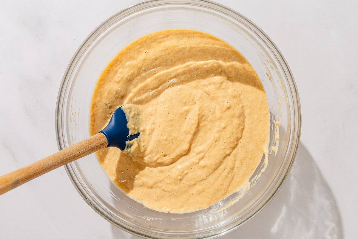 The batter for the gluten free sweet potato pancakes in a bowl with a spatula.